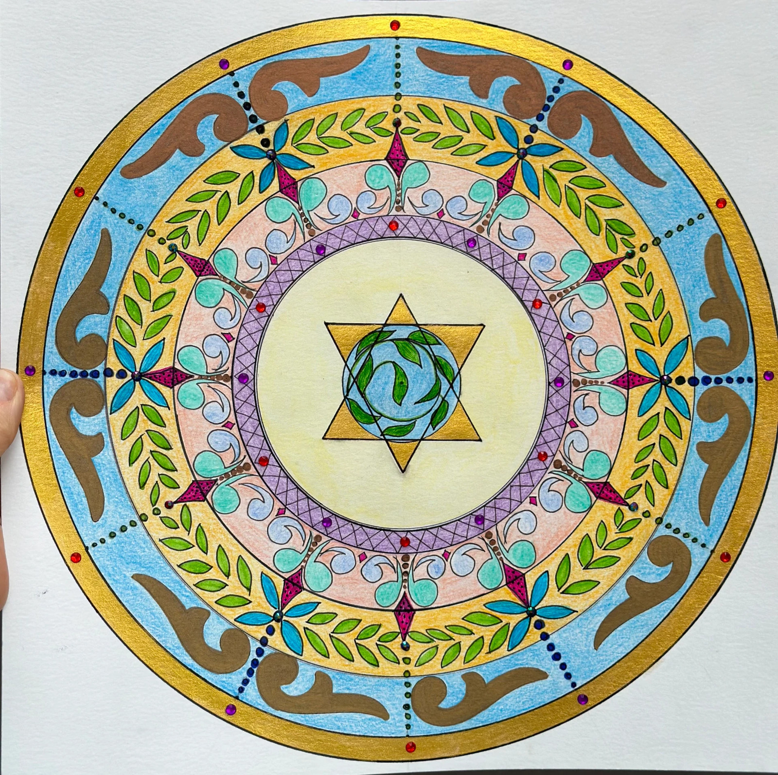 Spalvinga ranka kurta mandala su aukso žvaigžde centre